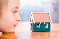 Child looking at a small home