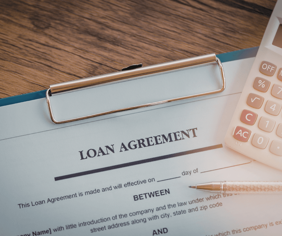 Loan agreement document on clipboard with calculator and pen on wooden desk, illustrating collateral assignment paperwork for life insurance borrowing